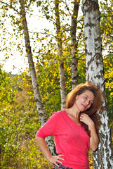 Portrait of a woman in nature. Happy woman in summer on a background of grass, flowers, greenery, forest.