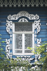 Ornamental window with decorative carved frame on vintage wooden rural house in Sudislavl town,...