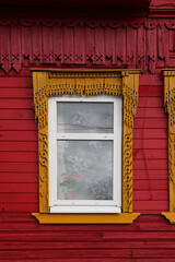 Decorated ornamental carved window and frame on vintage red wooden rural house in Galich town,...