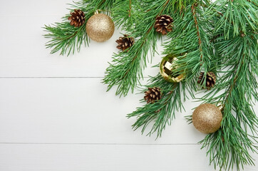 Green pine tree branches with cones and christmas decorations on white background