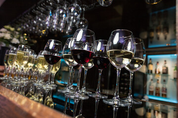 Side view of glasses of white and red wine on the table with shallow depth of field