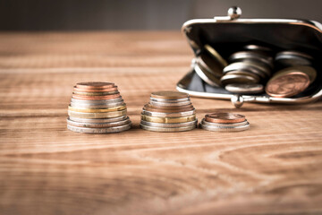 Wallet with coins on a wooden table. Close up. Selective focus. The concept of poverty.
