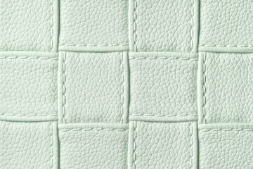 Fototapeta premium Texture of light green leather background with square pattern and stitch, macro.