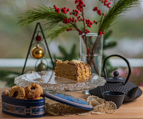 
The last piece of cake on a crystal stand, a samovar cup, and Christmas tree decorations on the table.