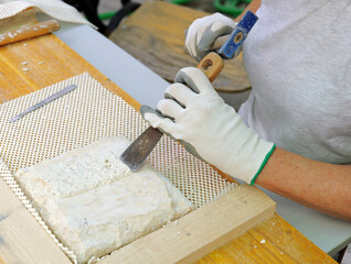 Removal by hand of the mortar of an old tile with a spatula. Restoration and conservation of...