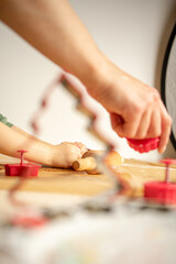 Young woman prepares gingerbread for Christmas, Pushes gingerbread shapes in dough on brown baking paper.