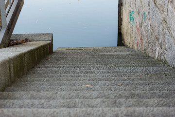 Descent to the river, stone staircase leading to the river, stone wall.