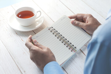 rear view of man's hand turning a page of a notepad 
