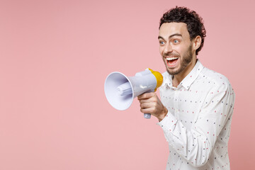 Excited cheerful shocked young bearded man 20s in basic casual white shirt standing hold in hand...