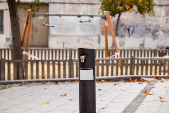 Drinking Fountain Closed With Blank Sign. Empty Blocked Children Playground With Caution Tape In Residential Area, During State Of Emergency Due To Coronavirus Outbreak, Lockdown. 