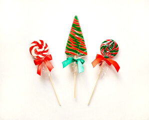 bright sweet christmas lollipops on white background