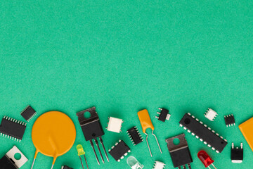 Electronic components over green background with copy space. There are microcontrollers,...