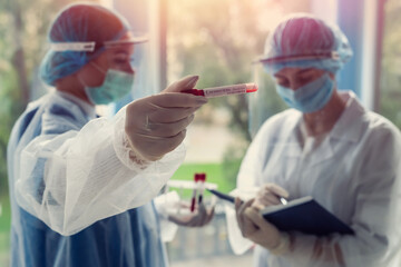 interns record the results of a laboratory test for coronavirus in a modern clinic
