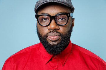 Close up of handsome serious young bearded african american man 20s wearing casual red shirt cap...