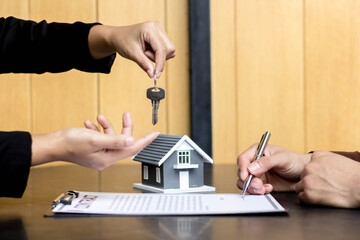 The lessor is handing over the keys to the tenant. Concept of purchasing new apartment. - obrazy, fototapety, plakaty