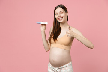 Fototapeta na wymiar Young pregnant woman future mom in basic top belly stomach tummy with baby hold in hand positive pregnancy test isolated on pastel pink background studio Maternity family pregnancy gynecology concept
