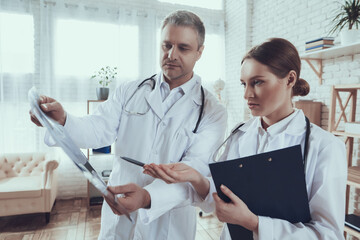 Two doctors are standing in the office. 