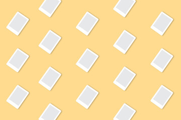 Trendy technological pattern made with white e-book on bright light yellow background. Minimal technological concept