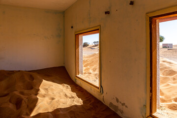 Neglected house interior buried in the sand in Al Madam ghost village in United Arab Emirates.