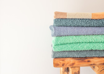 Lots of colorful bath towels stacked on each other. Isolated cotton towels for hotels, home,...
