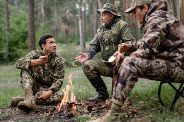 Hunters at Camp Fire Men Have Food and Talk.