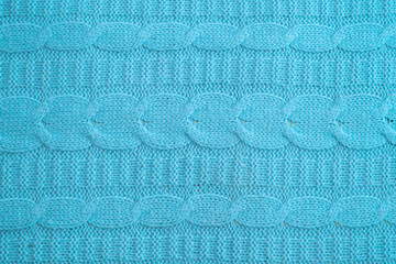 Blue knitted wool texture with a pigtail pattern. Big close up. Can use as background.