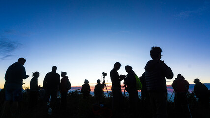 Group of silhouette happy travel friends on background of sunset or sunrise high mountain