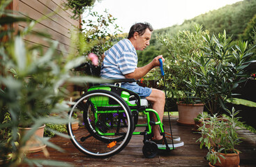 Senior man in wheelchair doing exercise on terrace.