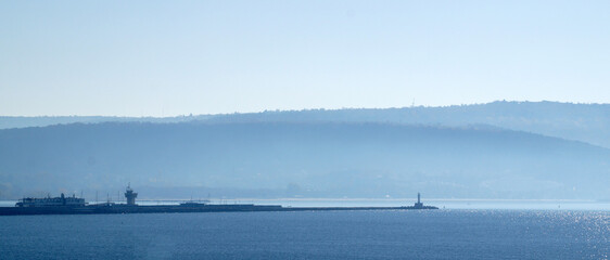 seascape, coast with a lighthouse in a blue haze