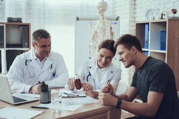 Doctors sit at the table and prescribe medication.
