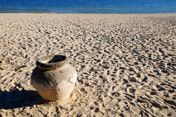 Fototapeta na wymiar ancient clay pot on the sandy seashore close-up