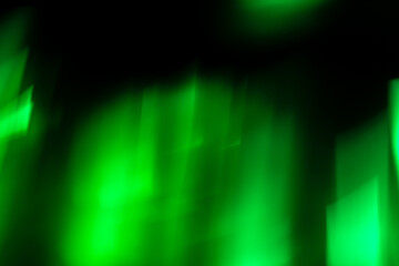 Defocused abstract green background of speed camera movement over glowing lights.