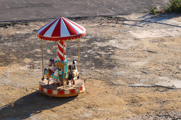 abandoned children's carousel in a vacant lot
