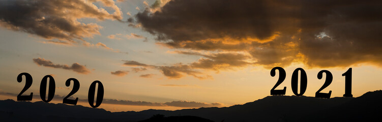 Happy New year 2021 letters on the mountain with sunset light, Silhouette of year 2021 with sunrise on mountain for New year success, Starting of New year concept.
