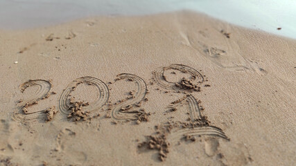 inscription 2020  2021 on beach sand