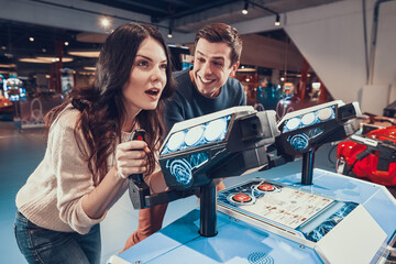 Man and woman have fun playing shooting games. 