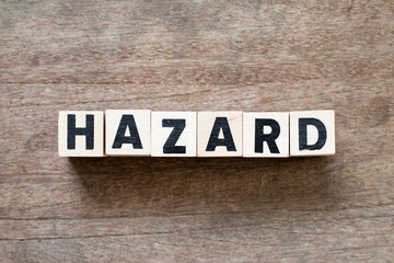 Alphabet letter block in word hazard on wood background