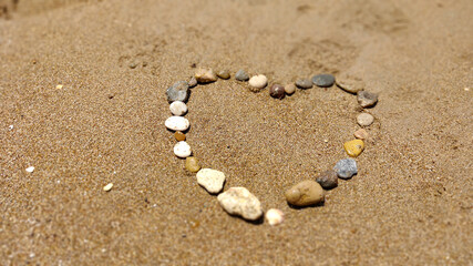 symbol of the heart drawing stones on the sand