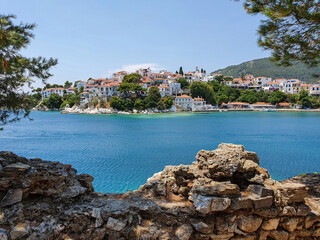 Fototapeta na wymiar View through ruins of stones to the old part of the town of Skiathos on Skiathos island, Greece.