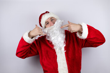 Man dressed as Santa Claus standing over isolated white background doing the “call me” gesture with her hands.