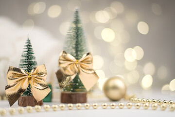 Fototapeta na wymiar Little Christmas trees decorated and gifts for the new year on the bokeh background, new year mood 2021