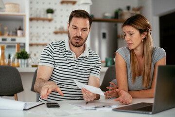 Husband and wife preparing bills to pay. Young couple having financial problems.