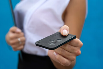 Young woman in business cloth hold car key on blue background