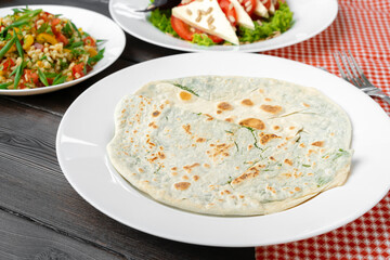 Homemade flatbread yantyk stuffed with cheese and greens