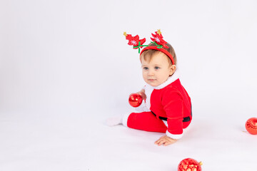a child in a Santa costume with red Christmas balls on a white isolated background, the concept of new year and Christmas, a place for text