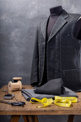 suit jacket on male tailor mannequin and sewing items