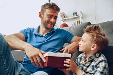 Little son gives his father a gift box for father's day