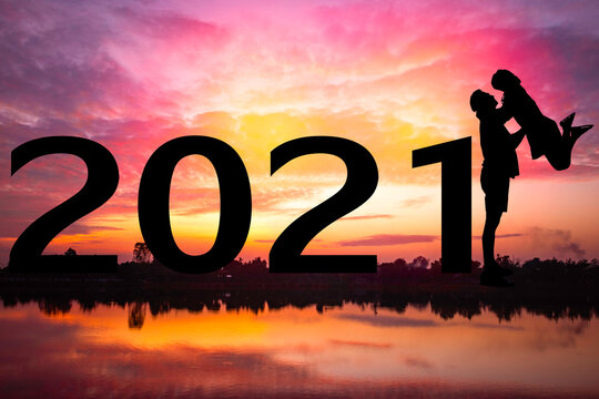 Happy new year Silhouette sunset background.Man standing and  lift woman.They are standing next to 2021.new year,2021,love,Photo Silhouette and new year