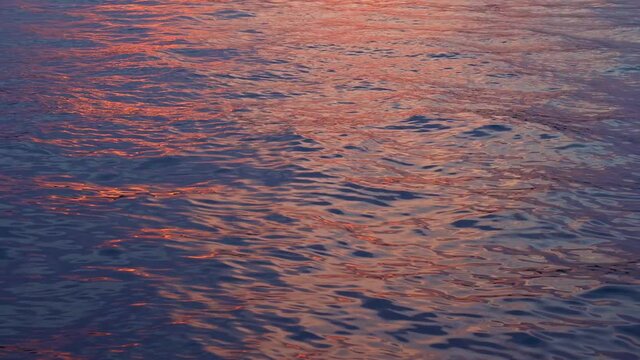 Beautiful sunset on the seaside. Amazing colors of the evening sky reflecting in the river. Small wawes in the water. Beautiful color of the sky .