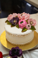 White cake with pink flowers on golden tray